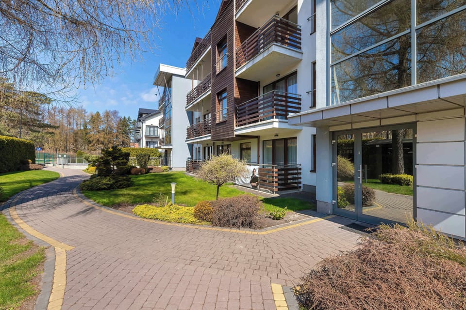 An exterior view of a modern apartment building with balconies. The architecture is clean and well-maintained.