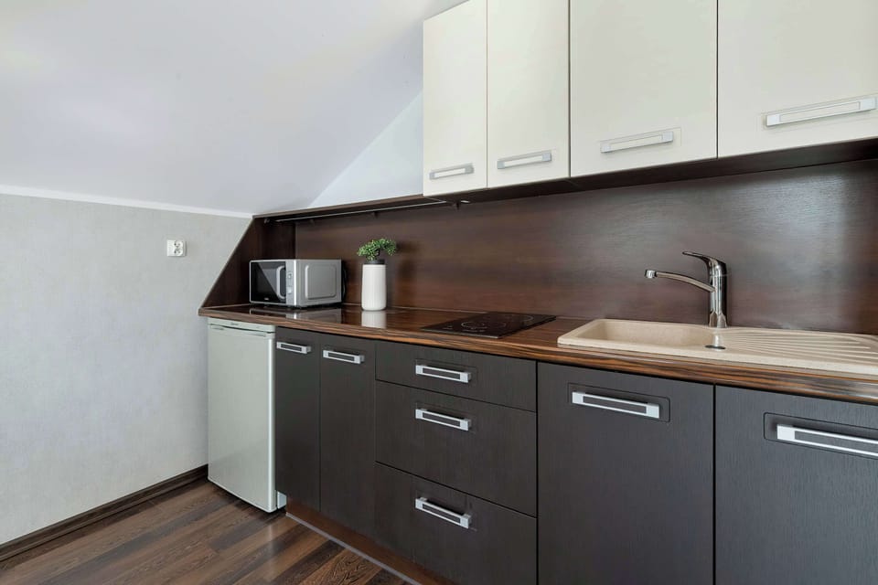 A compact kitchen with dark cabinets and a clean countertop. The layout is simple and functional for everyday cooking.