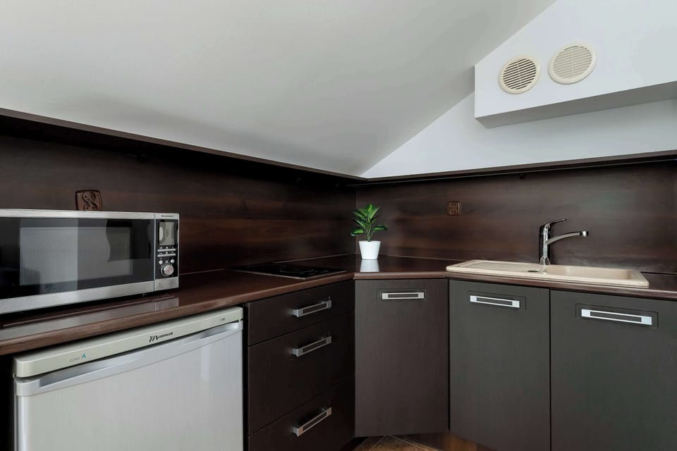 A fully equipped kitchen with dark cabinetry and built-in appliances. The layout is functional and designed for convenient cooking.