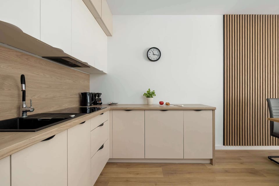A clean kitchen with light cabinetry, wooden accents, and a compact layout.