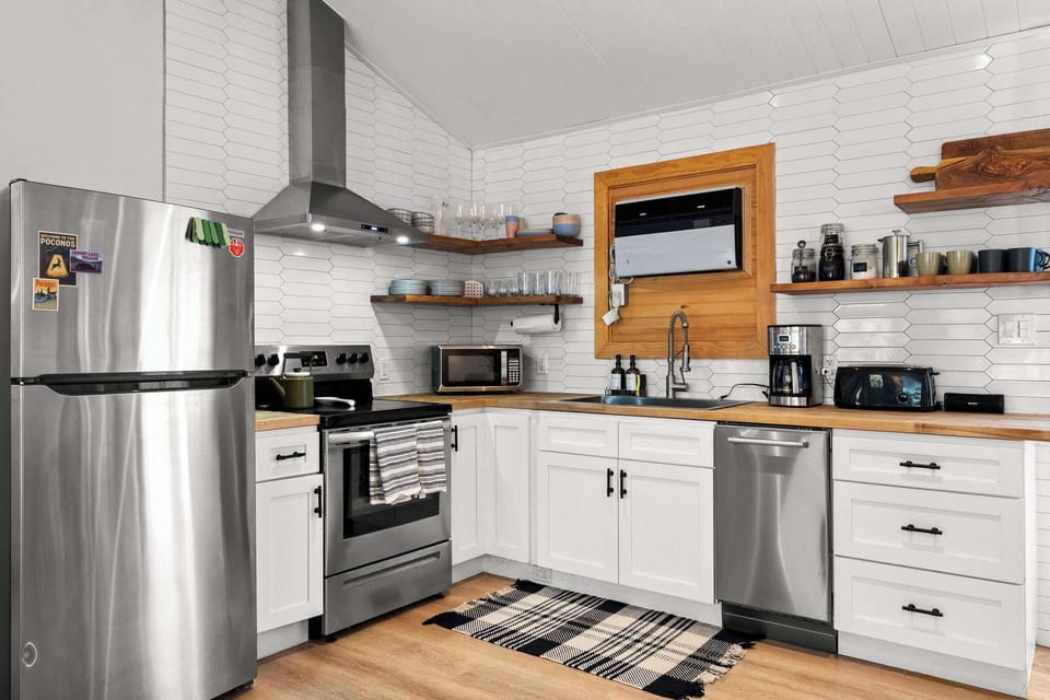 Kitchen with subway tile, open shelving, and stainless range