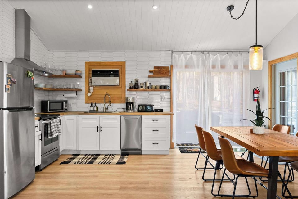 Crisp white kitchen with stainless appliances and table seating