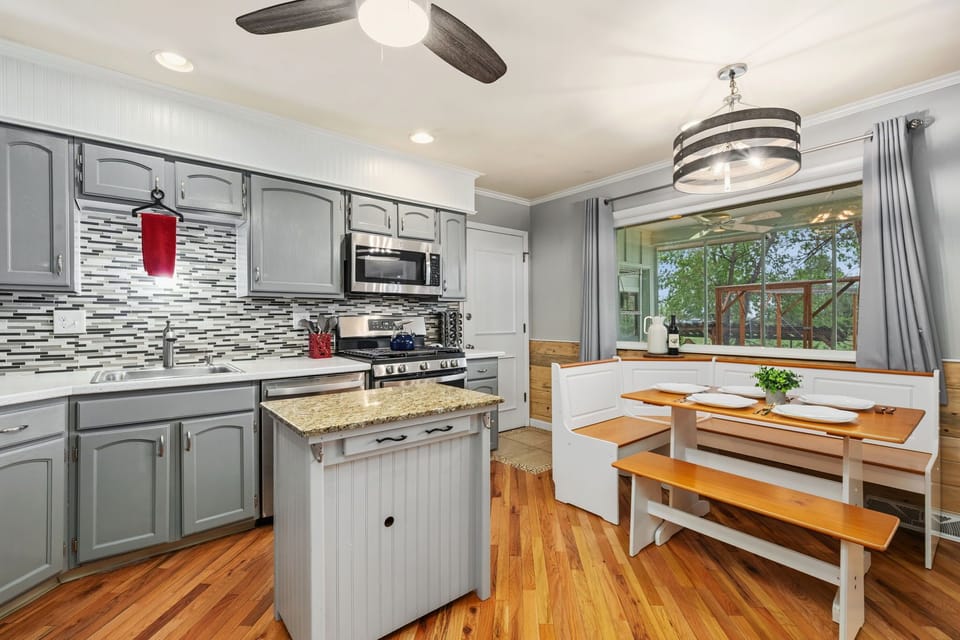 Fully equipped kitchen with granite counters, stainless appliances, and a cozy breakfast nook.