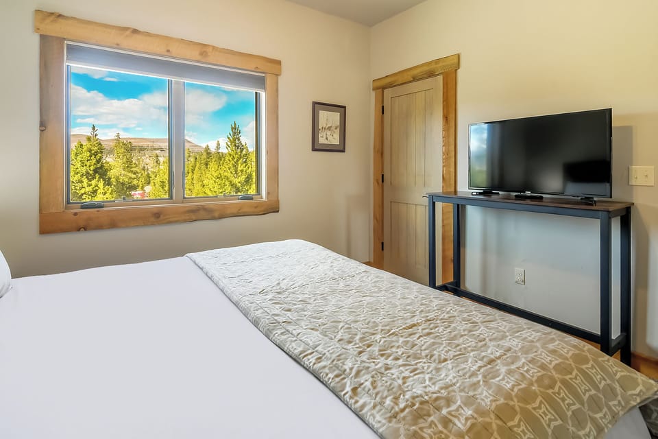 Wake up to stunning forest views from your cozy bedroom, where natural wood accents and modern amenities create the perfect mountain retreat.