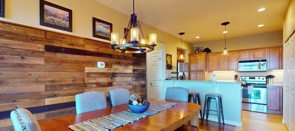 Gather around your rustic wood dining table while savoring the warm glow from the statement chandelier overhead.