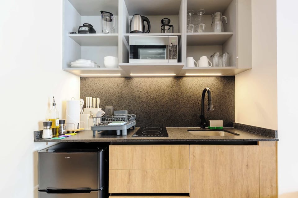 Compact kitchen with shelves, stove, and essential appliances.