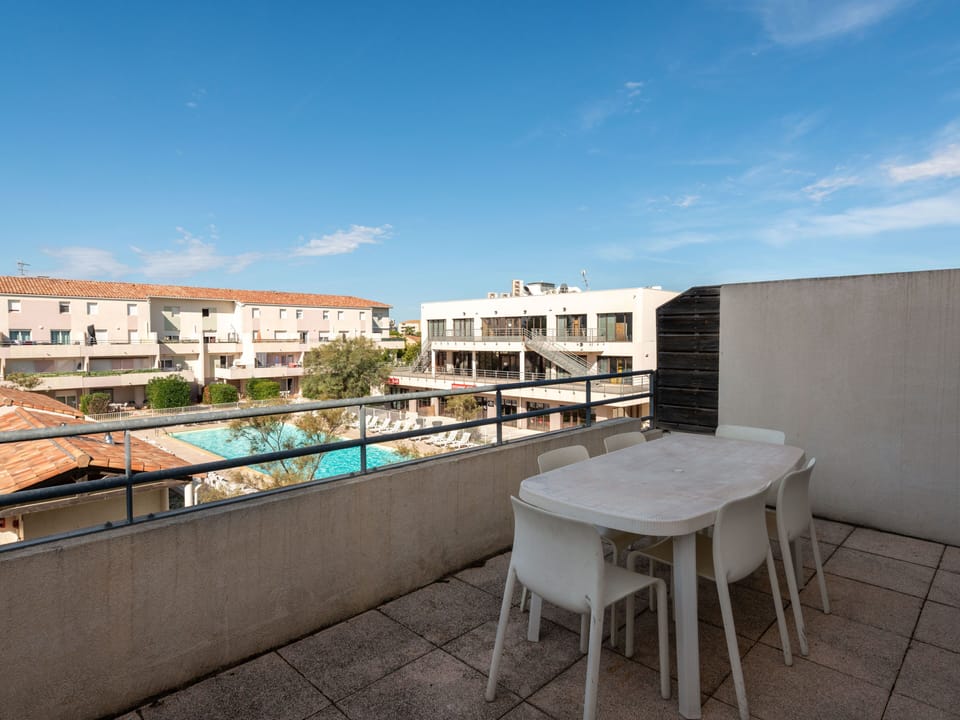 Step out onto the private balcony with outdoor seating and a direct view of the heated pool