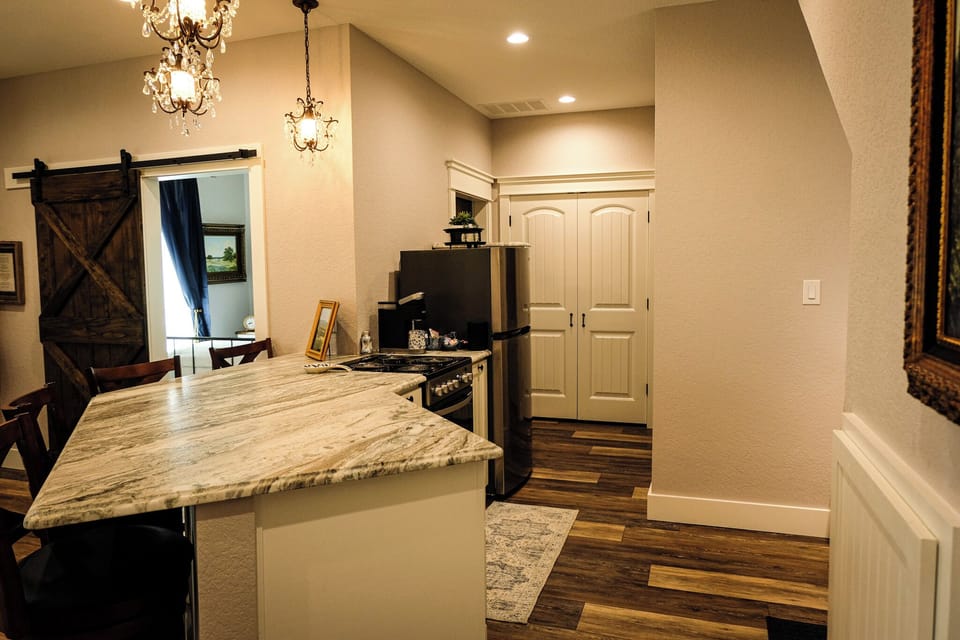 Charming kitchen with marble island, barn door, and elegant lighting