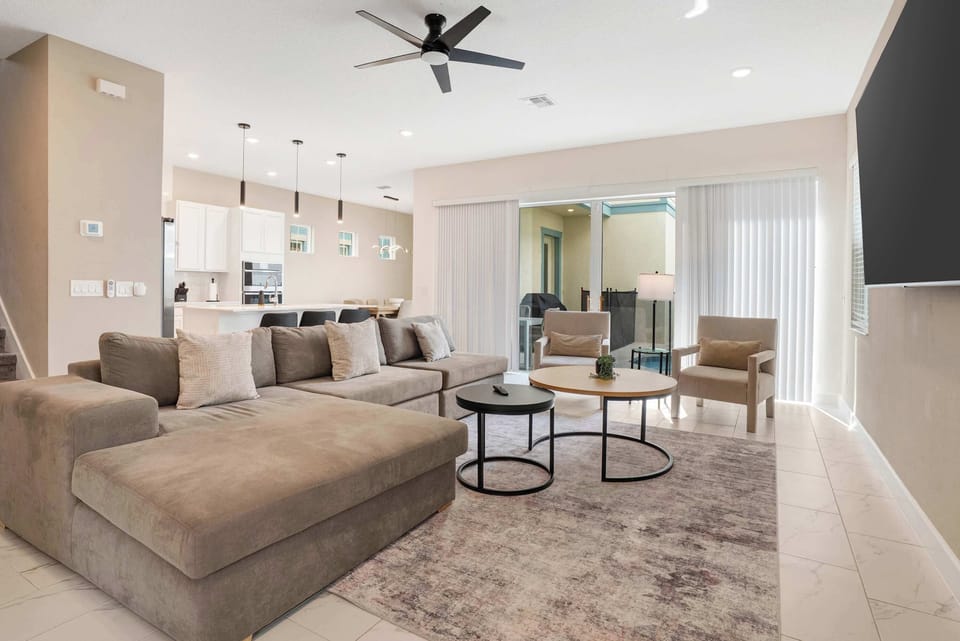 Modern living room with a large sectional sofa and sliding glass doors leading to a patio.