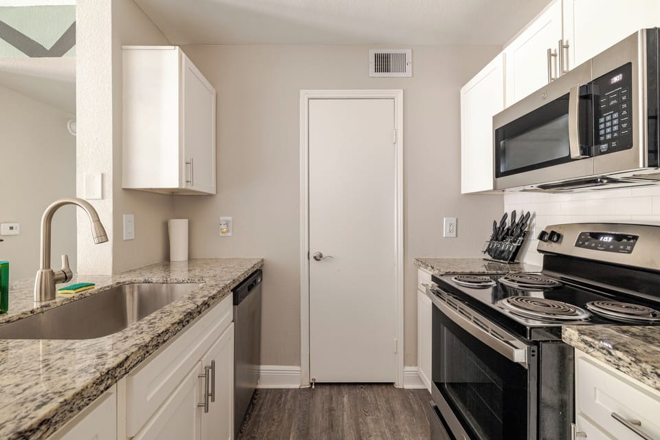 Bright modern kitchen with granite counters and stainless appliances