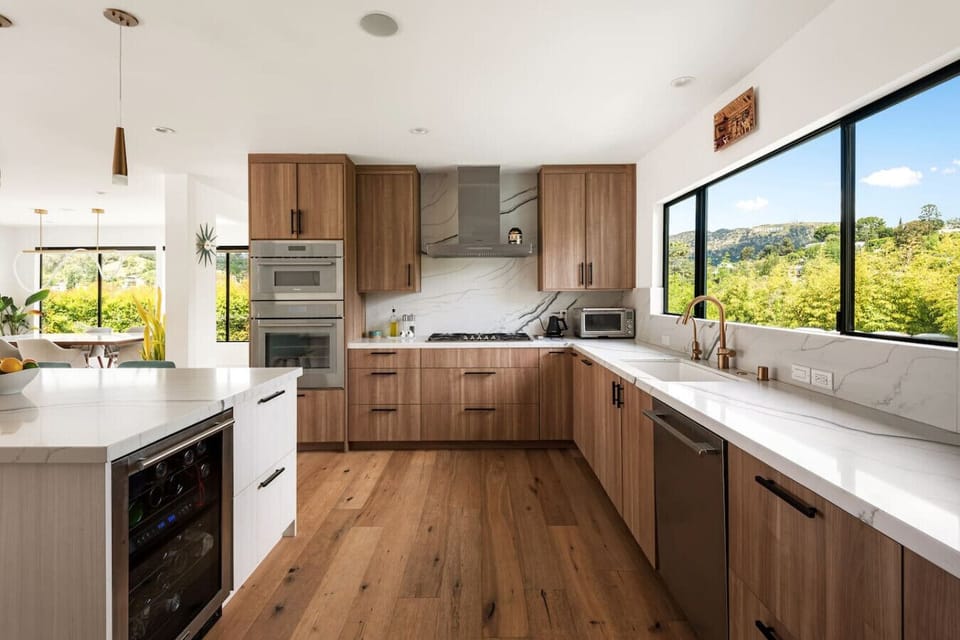 Flooded with natural light and surrounded by lush greenery, this thoughtfully designed kitchen offers ample counter space, modern appliances, and everything you need for a comfortable extended stay.
