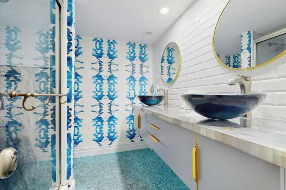 How cool is this Master Bathroom! With updated fixtures and wall coverings, guests will love this stunning master bath with dual vanities and a walk in shower