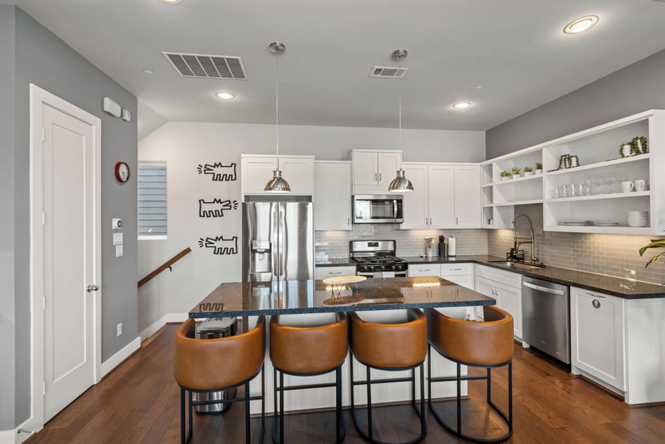 Modern chef’s kitchen with island seating for 4 and stainless appliances