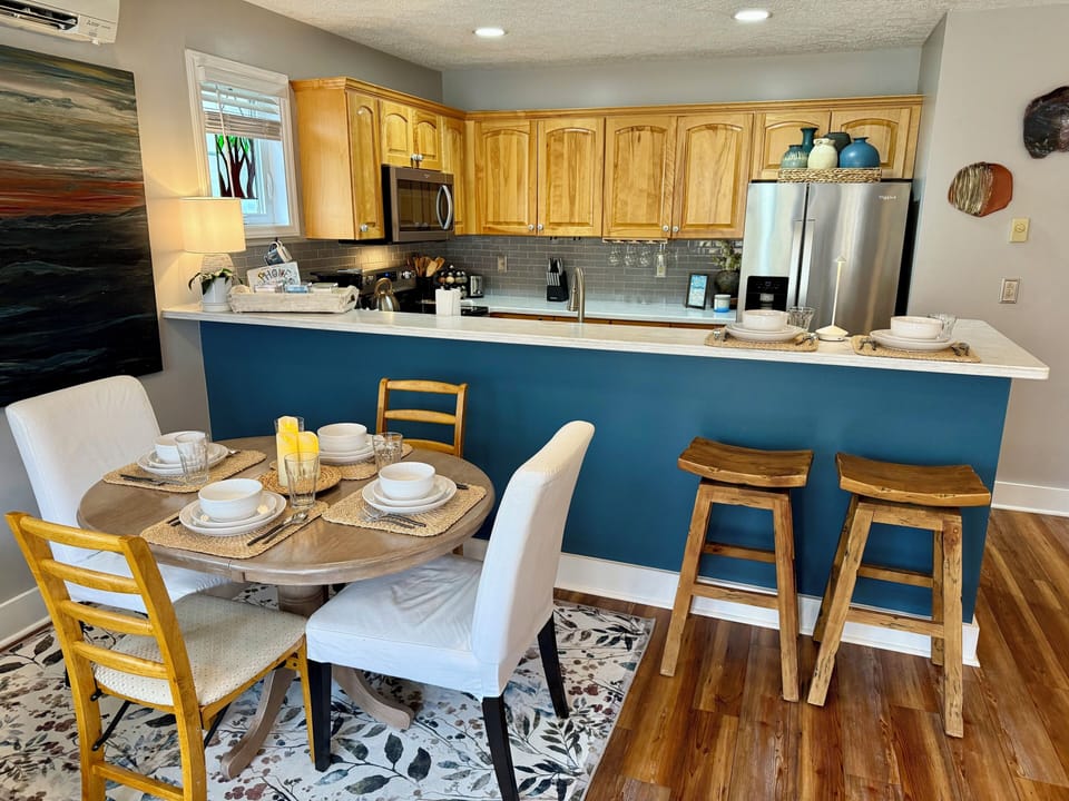 Bright kitchen and dining space with breakfast bar and seating for 6