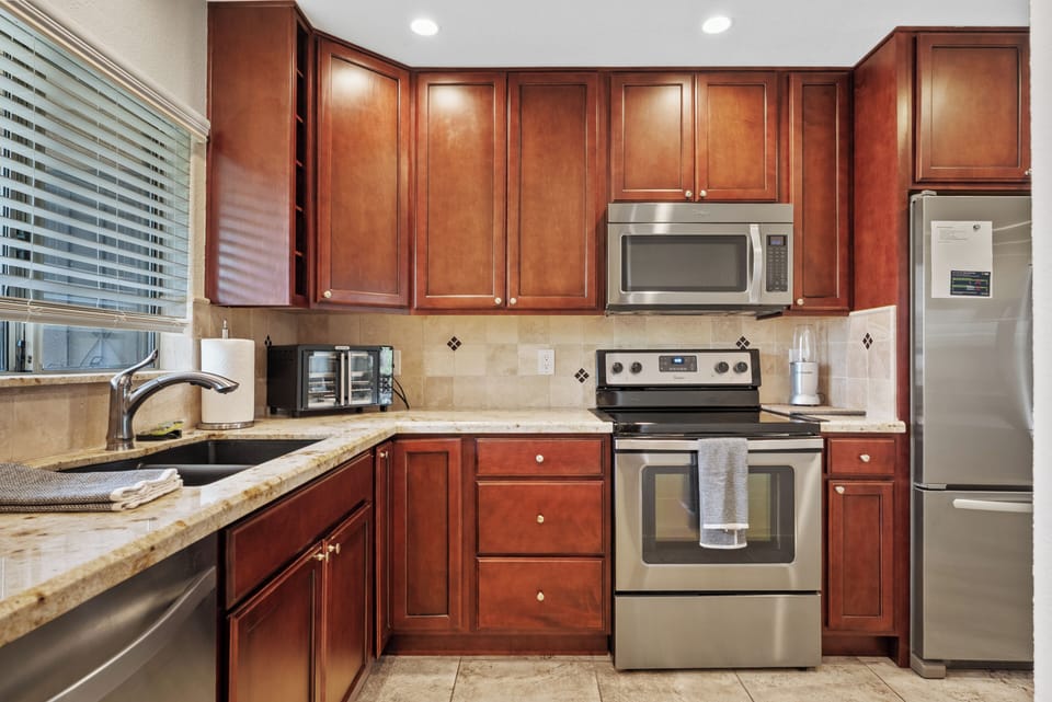 Spacious kitchen with stainless steel appliances, ample cabinetry, and generous counter space for easy meal prep.
