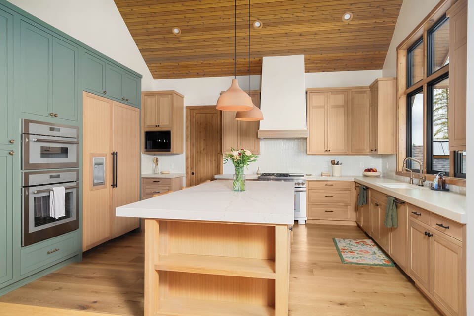 Chef's kitchen with a large quartz-topped island, smart appliances, and ample cabinet storage — designed to handle meals for the whole crew.