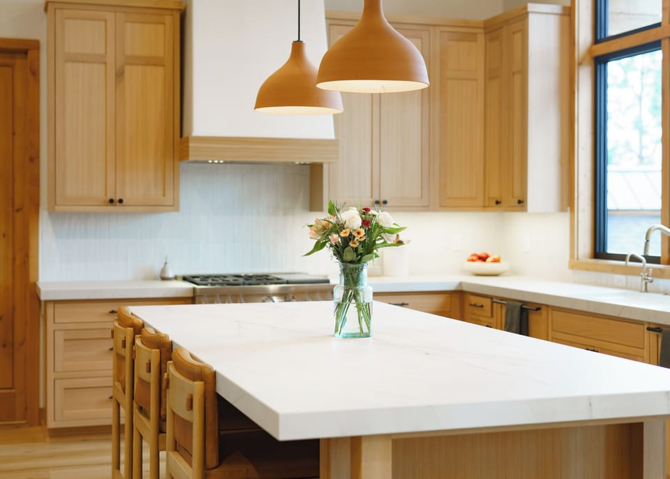 Spacious quartz kitchen island with fresh flowers and plenty of prep space — beautiful, functional, and ready for your next big dinner party.