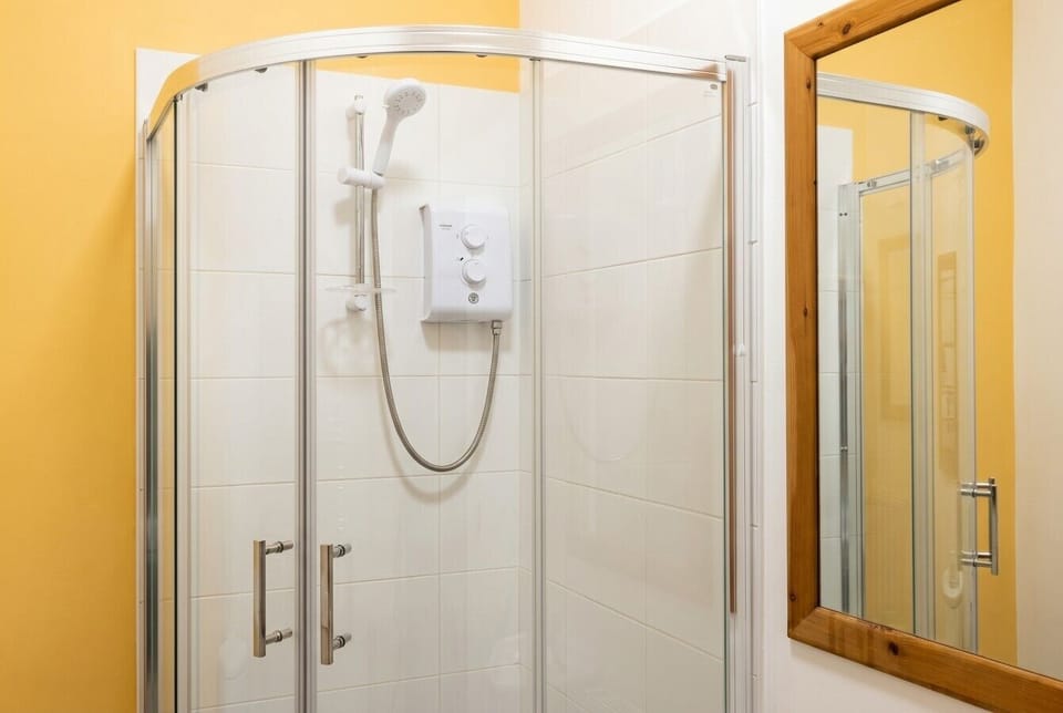 Sparkling glass corner shower with a power head, ideal for freshening up between explorations.