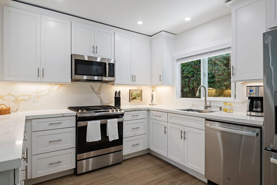 Your fully equipped kitchen sparkles with white cabinets, quartz countertops, and stainless appliances—perfect for preparing meals in style.