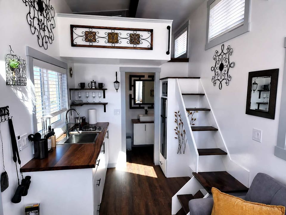 Modern kitchen featuring a two-burner cooktop, microwave, refrigerator with freezer, and smart storage. Designed to maximize space while providing everything needed for a comfortable and convenient stay.
