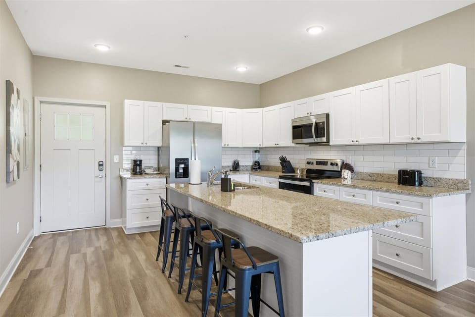Gather here first—set the snacks out, open the fridge, and make yourself at home. With stainless appliances and plenty of counter space, this kitchen is ready for everything from quick bites to full meals.