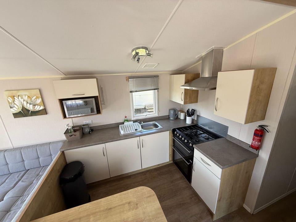 The open plan kitchen and living area is perfect for keeping up with the conversations. This modern caravan on Steeple Bay is the perfect place for a staycation in Essex. Book todya with 2cHolidays