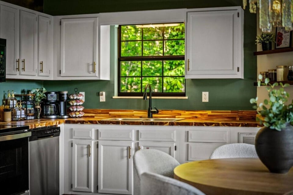 Fully equipped kitchen with coffee and waffle bar essentials, wooded views, and everything you need for easy meals at the cabin.