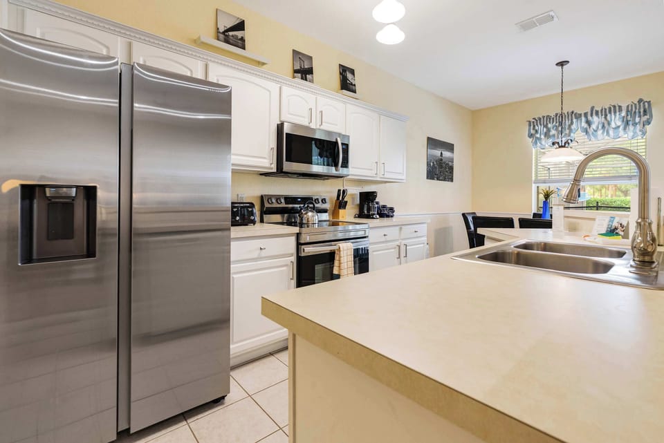 Modern kitchen with stainless steel appliances and a spacious island for meal preparation.