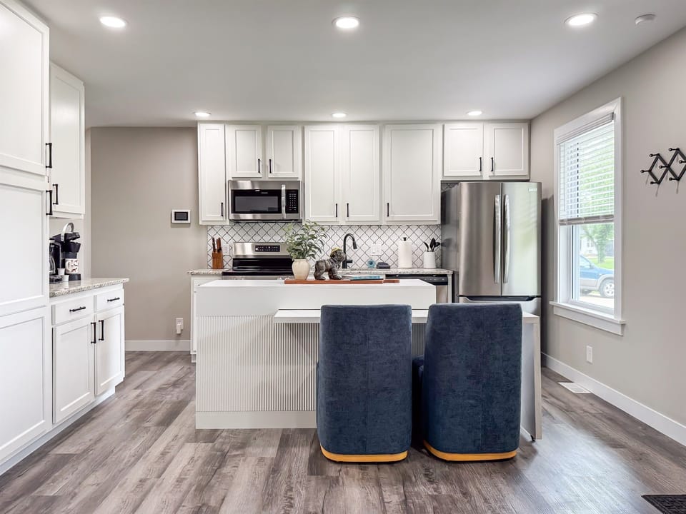 Bright and beautiful! This kitchen features a fresh, modern design equipped with everything you could need, making your stay easy and convenient. The sleek breakfast bar makes for the perfect spot to enjoy a cup of coffee or a quick bite to eat.