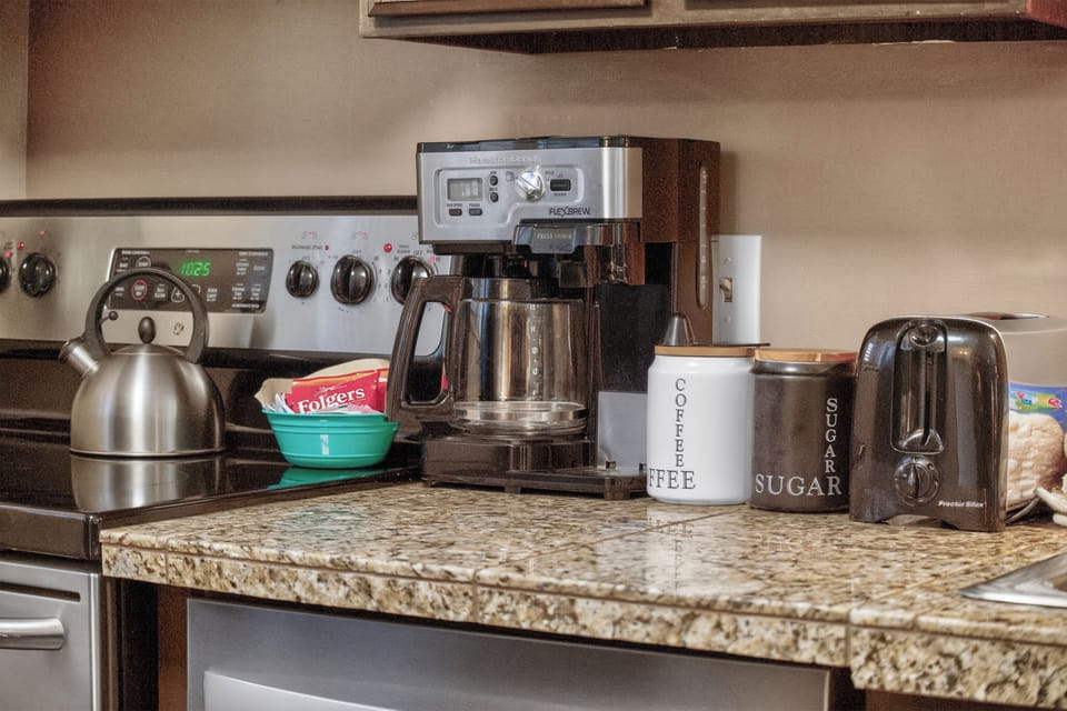 Start your mornings right with this fully-equipped coffee station—everything you need for that perfect cup awaits on beautiful granite countertops.