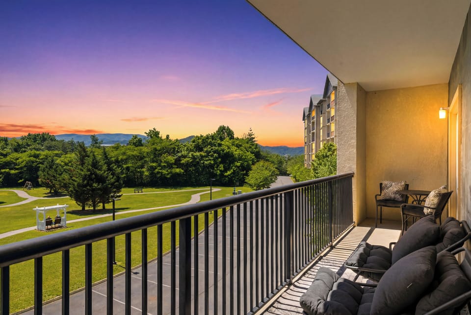 Private sunset balcony with plush seating, park views, and mountain scenery