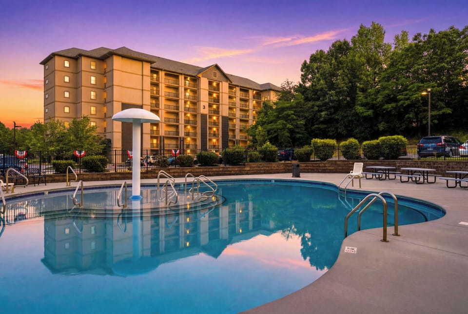 Resort-style outdoor pool with sunset views and relaxing guest seating