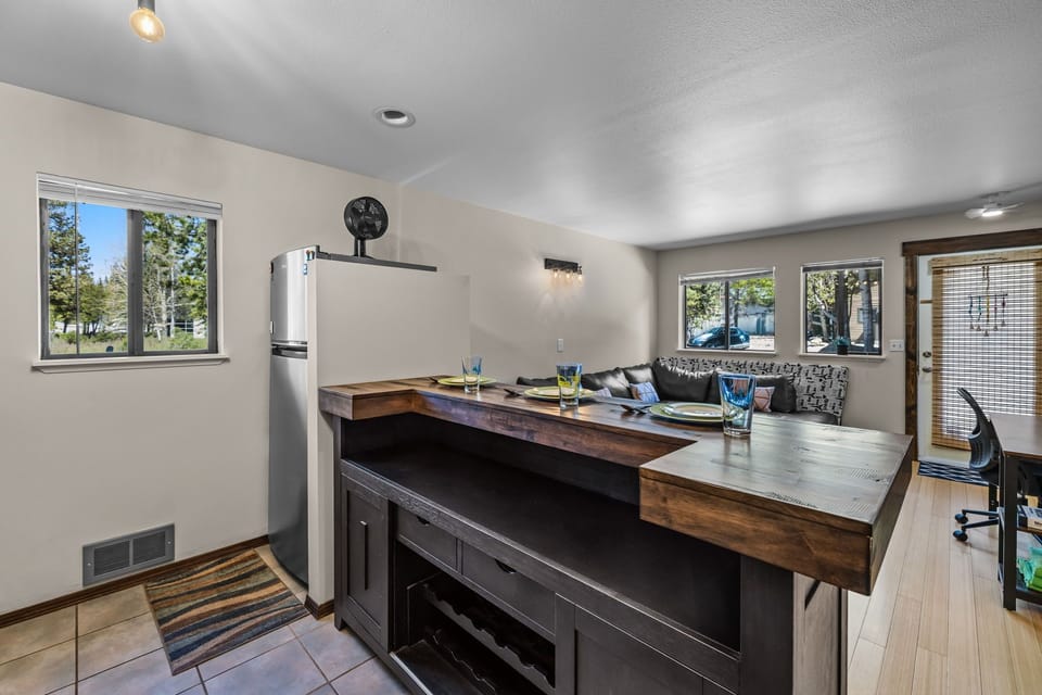Your stylish kitchen features rich wood countertops and modern appliances, perfect for preparing meals while enjoying forest views through large windows.