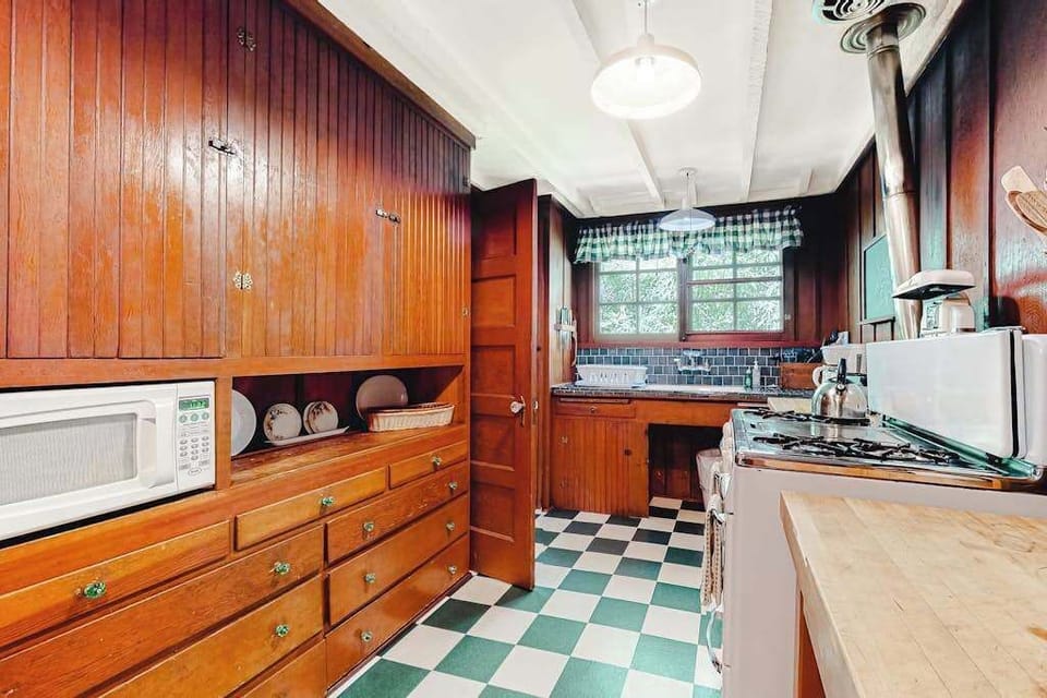 Stock your full kitchen with Sonoma farm-stand finds — custom wood cabinetry, open shelving, microwave, and a charming checkerboard floor underfoot.