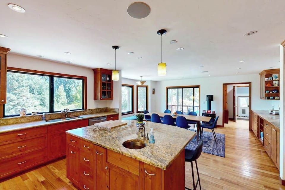 Channel your inner chef on the expansive granite island — pendant lights glow above while panoramic windows bring the surrounding redwoods right into your kitchen.