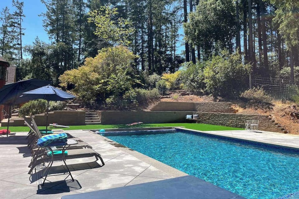 Settle into a poolside afternoon surrounded by redwood-studded hillsides — your heated pool sparkles under wine country sun with lounge chairs set for relaxation.