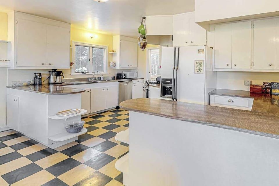 Cook like a local in this retro-charming kitchen — classic checkerboard floors, generous counter space, and a full suite of appliances make farm-to-table prep a breeze.