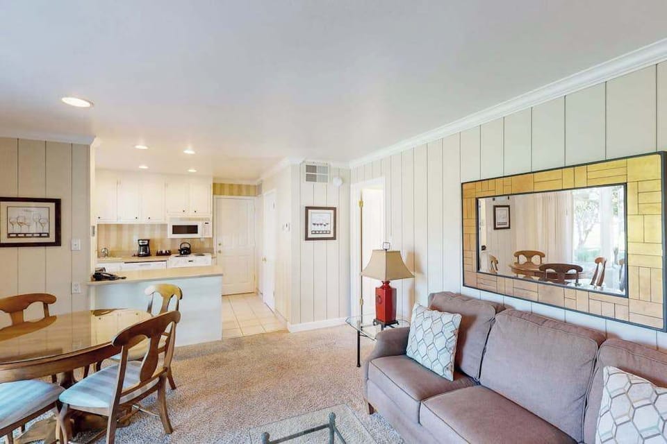Gather around the dining table or stretch out on the sofa — your open living area flows into a full kitchen through a convenient pass-through counter.