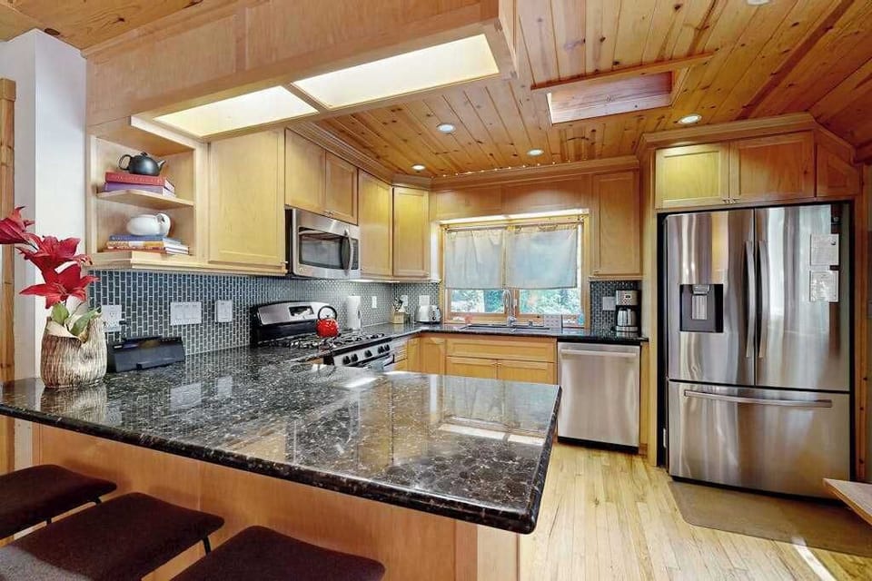 Prep your charcuterie spread on gleaming granite countertops — your fully stocked kitchen includes a coffee maker, microwave, and bar seating for casual bites.