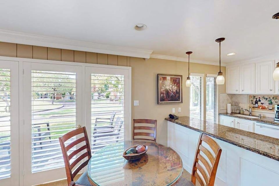 Savor your morning coffee at the dining table as natural light pours through French doors overlooking the resort's manicured grounds