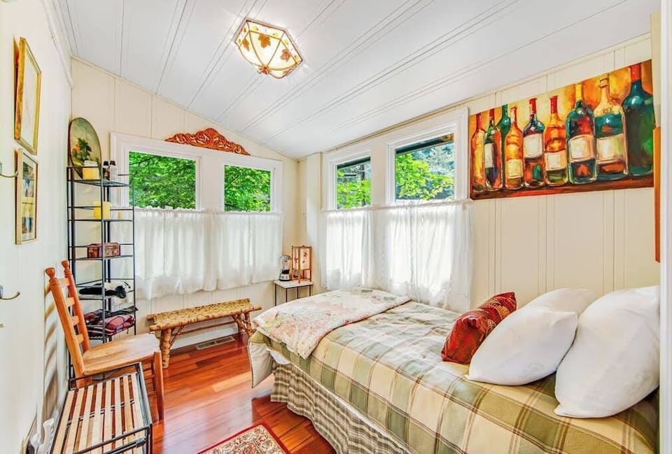Tuck into your cozy wine-country-themed nook with a charming twin bed, bottle-inspired art, and bright windows peering into Guerneville's forest — perfect for a young traveler.
