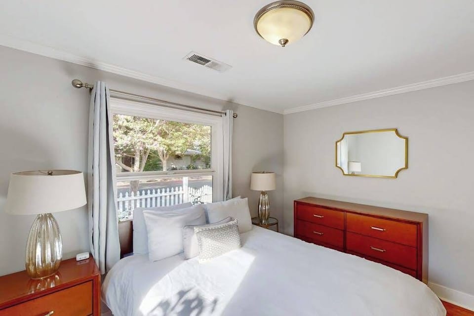 Afternoon sun spills across your guest bed with a peek at the white picket fence outside — a peaceful retreat steps from Santa Rosa's best restaurants