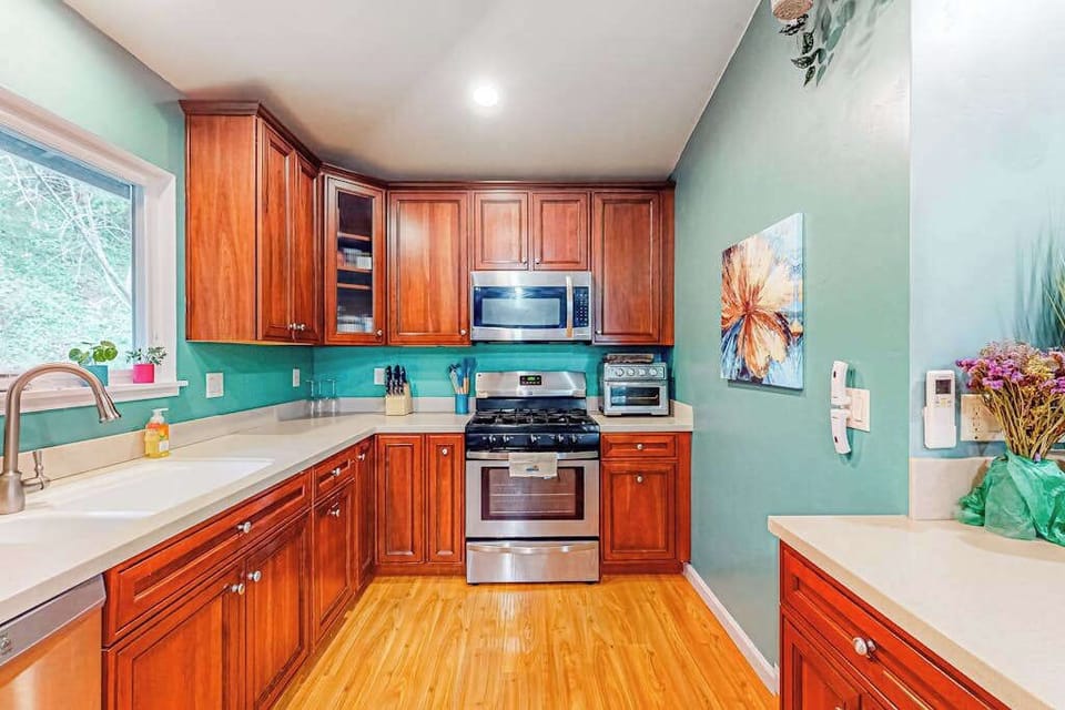 Whip up breakfast with a view of the greenery through your kitchen window — gas range, ample cabinetry, and art-filled walls make mornings here feel special.