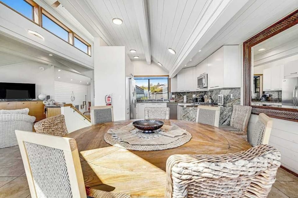 Share fresh Fishetarian Fish Market catch around your round wood dining table — wicker chairs and an open kitchen make meals feel effortless
