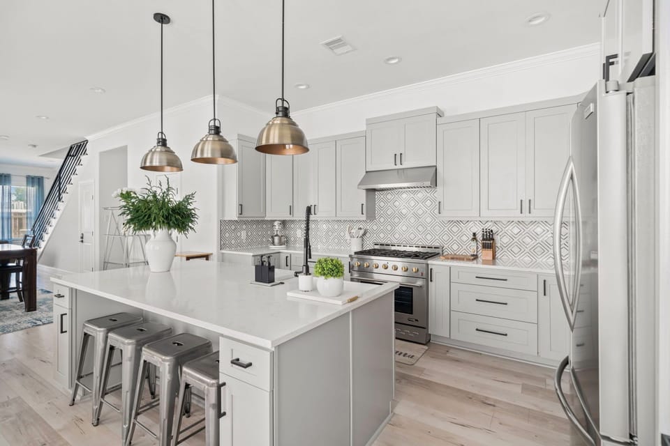 Bright designer kitchen with large island seating and stainless appliances