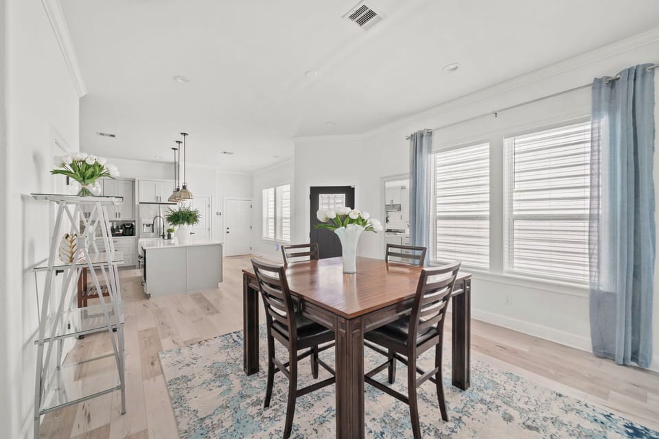 Bright open dining area with modern kitchen and abundant natural light