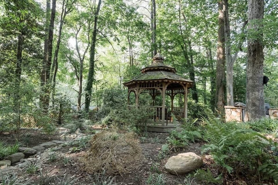 Charming gazebo illuminated by soft string lights offering a peaceful evening retreat surrounded by nature.
