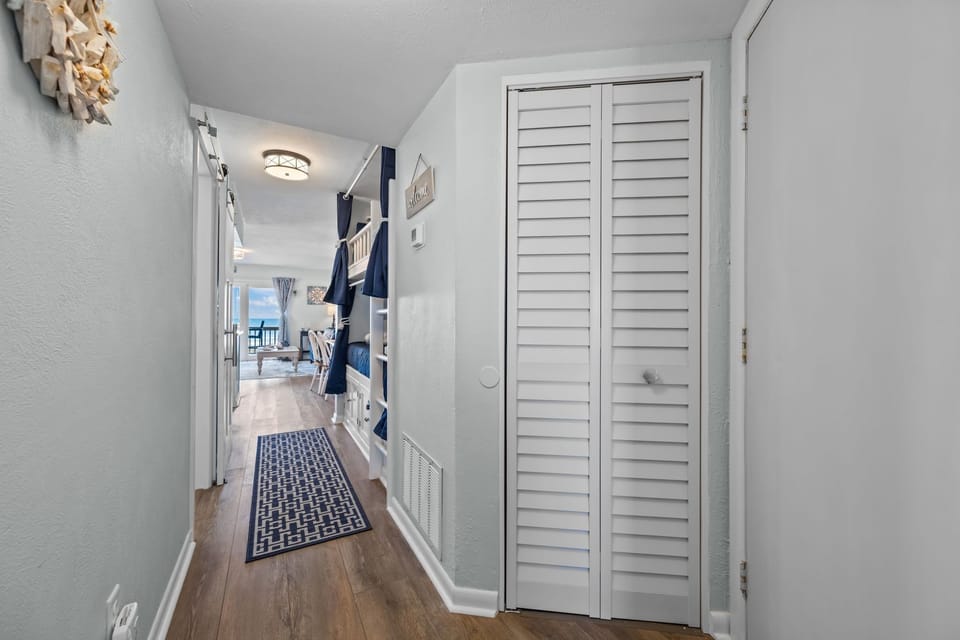 Hallway view connecting sleeping, living, and balcony areas for an easy, flowing layout