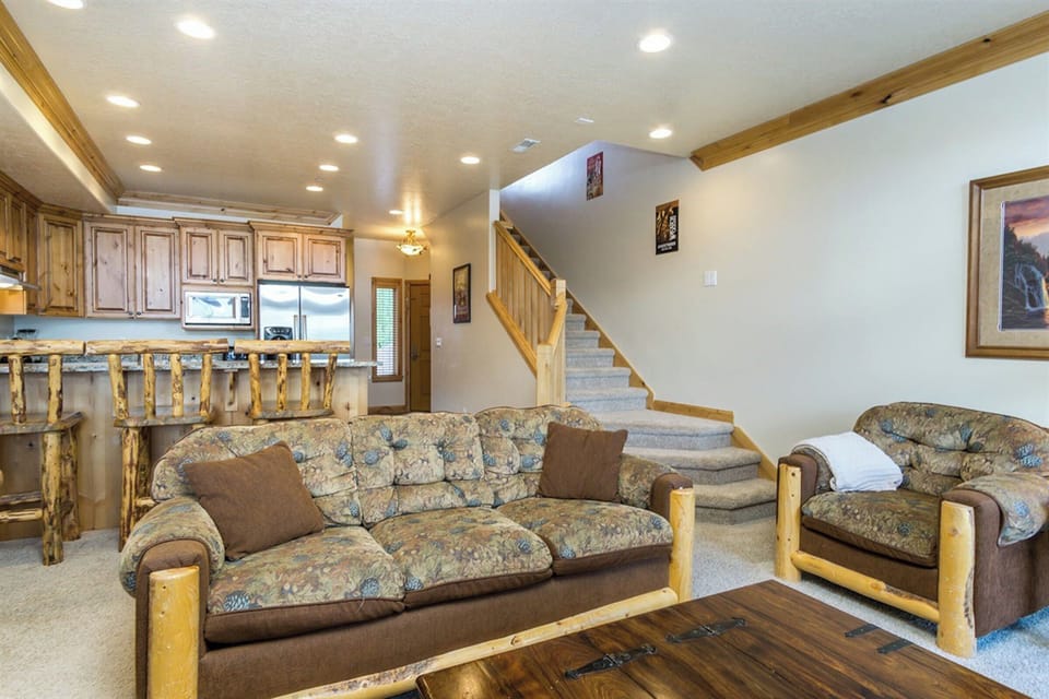 A spacious living area with plush seating and warm wood accents, offering a relaxed yet refined setting for unwinding after a day of adventure.