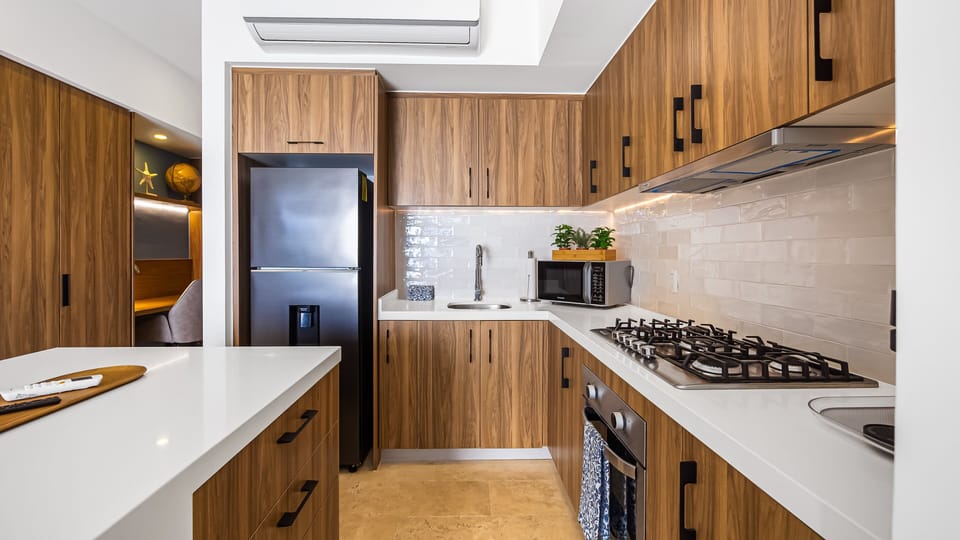 Fully equipped kitchen with clean lines, white countertops, and warm wood cabinetry, perfect for cooking, entertaining, or casual meals.
